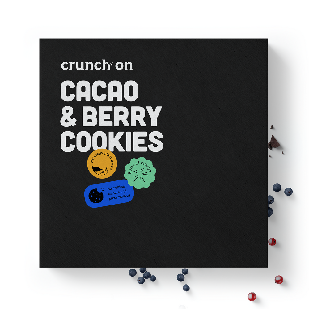 Front view of box of Crunch On Cacao & Berry Cookies - 48 cookies, with chocolate and berries in the background