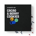 Front view of box of Crunch On Cacao & Berry Cookies - 24 cookies, with chocolate and berries in the background